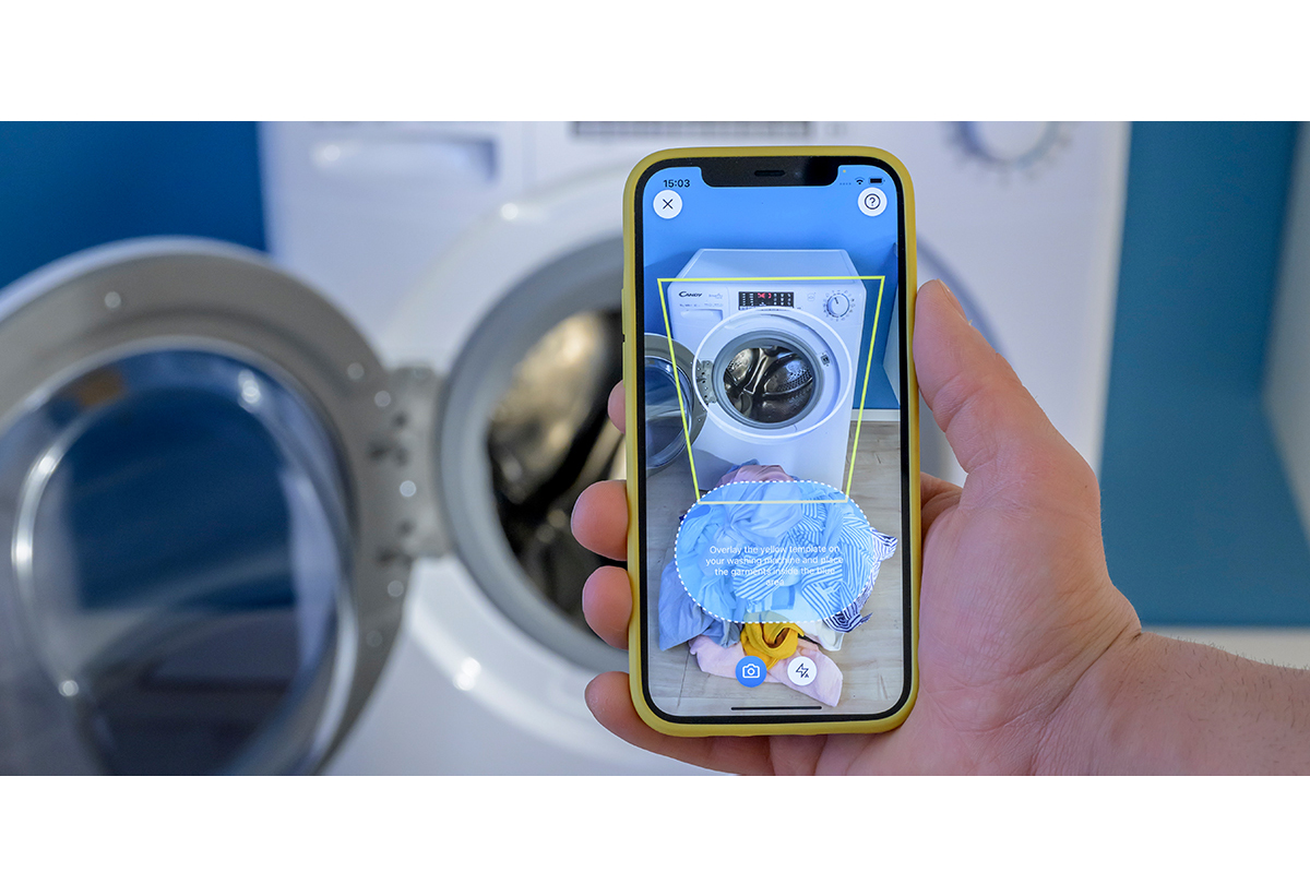 Απεικονίζεται το πλυντήριο και ένα smartphone ενώ φαίνεται η εφαρμογή hon
